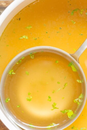 close up of a ladle full of chicken bone broth