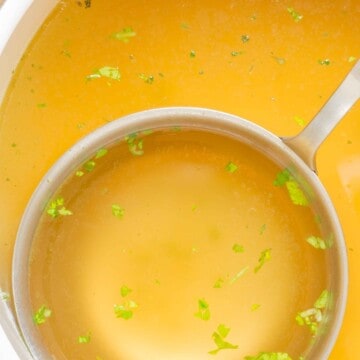 close up of a ladle full of chicken bone broth