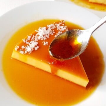 a spoon drizzling caramel over a slice of coconut flan