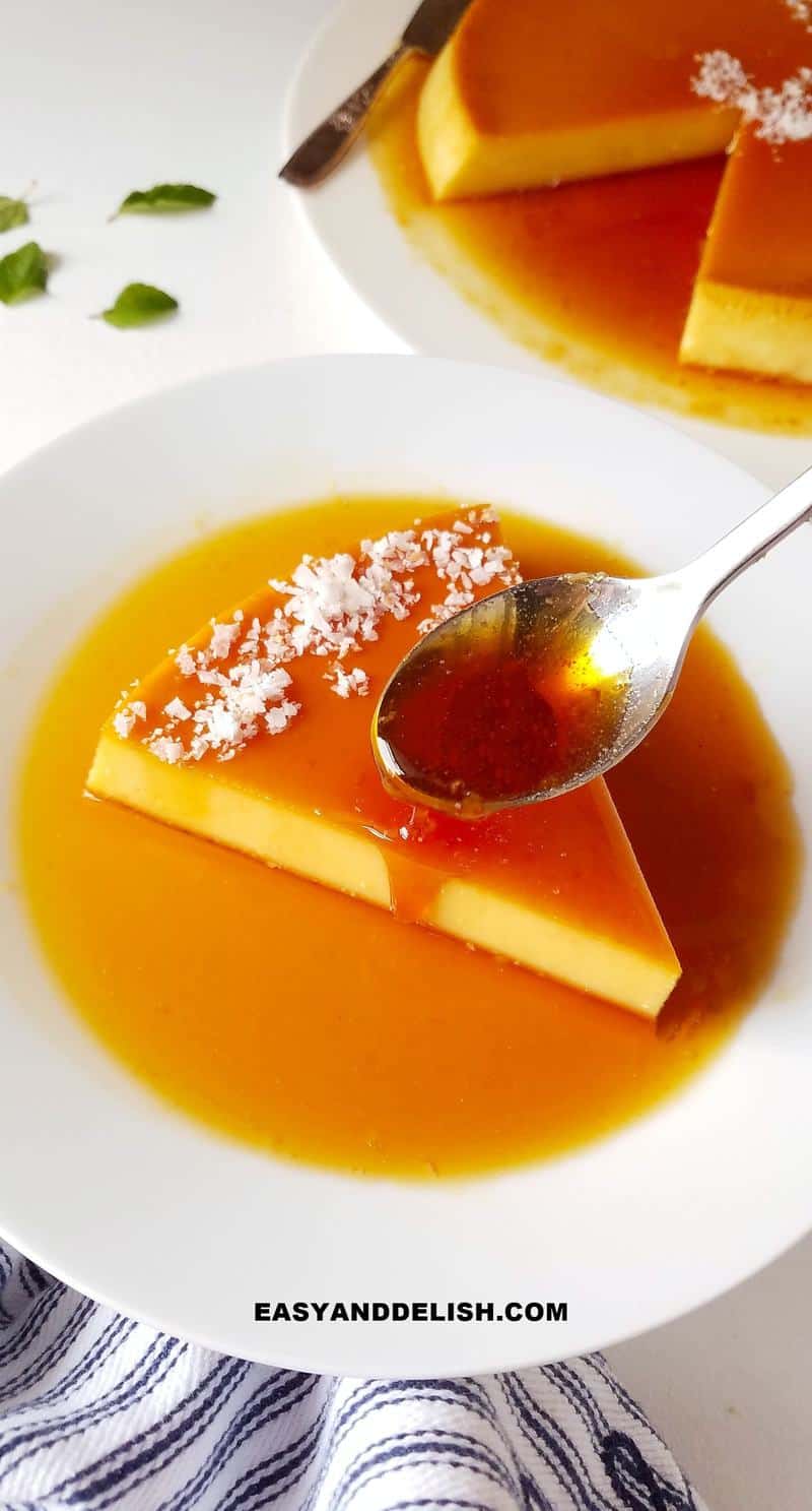 a spoon drizzling caramel over a slice of coconut flan