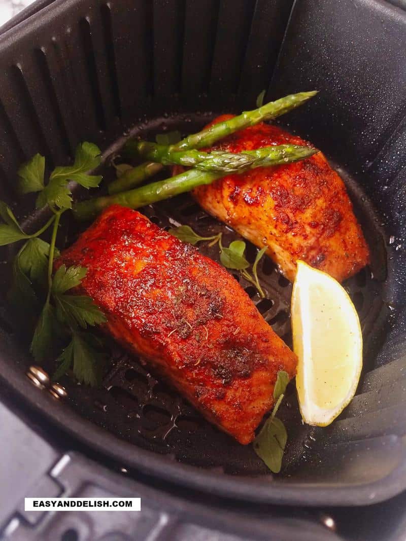 salmon in air fryer with lemon wedge and asparagus