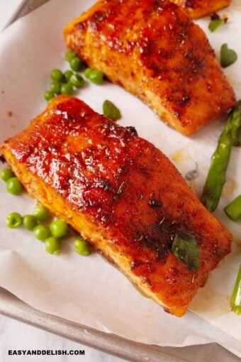 cooked fish with veggies resting in a baking sheet