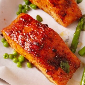 cooked fish with veggies resting in a baking sheet