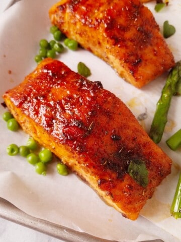 cooked fish with veggies resting in a baking sheet