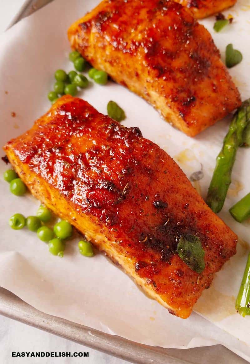 cooked fish with veggies resting in a baking sheet