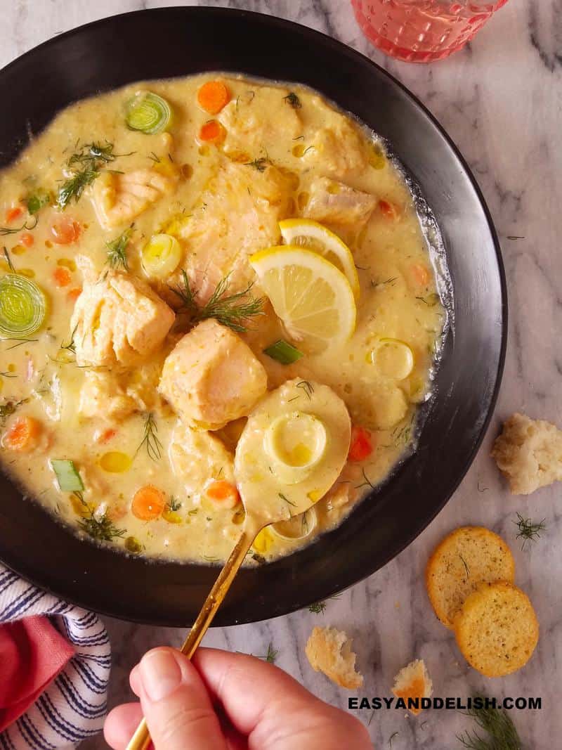 uma colher sendo enfiada na tigela de sopa de peixe cremosa