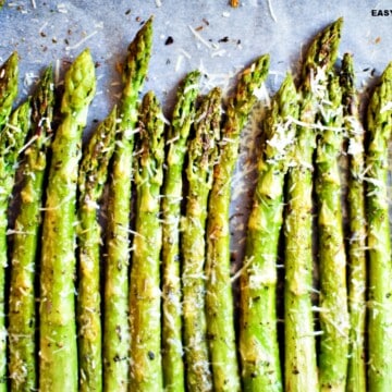 air fryer asparagus seasoned and lined up in a baking sheet