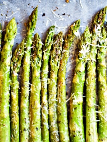 air fryer asparagus seasoned and lined up in a baking sheet