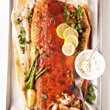baked blackened salmon on a tray with garnishes