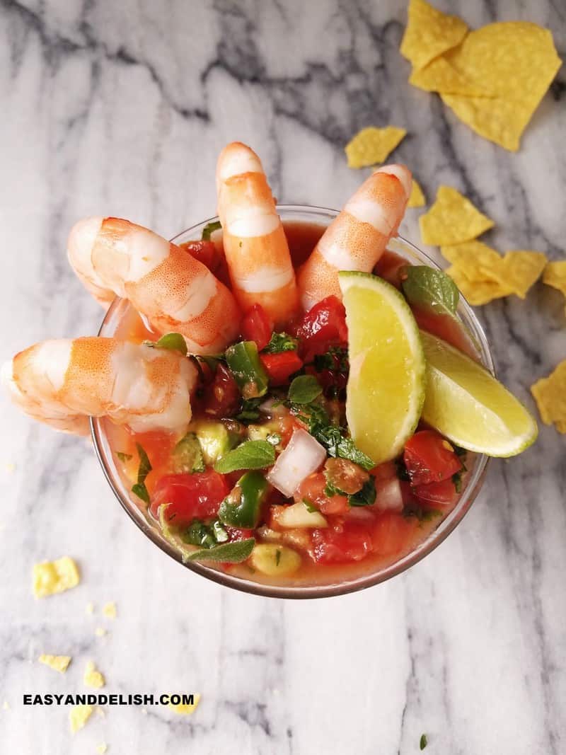 shrimp cocktail served in a glass with tortilla chips on the side