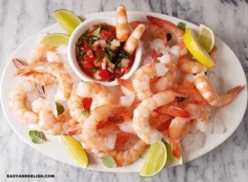 a platter with coctel de camarones and lime wedges