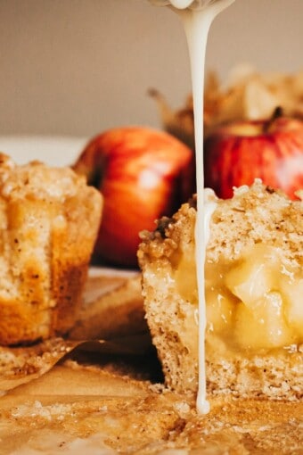 whole and cut in half drizzled apple crumble muffins