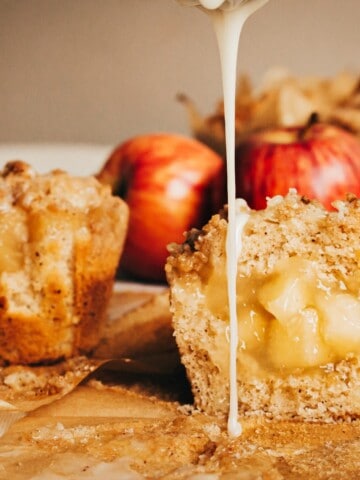 whole and cut in half drizzled apple crumble muffins