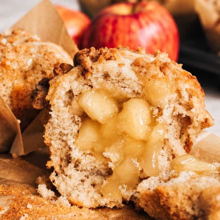 Apple muffin cut open to show the soft apple pie filling in the center.
