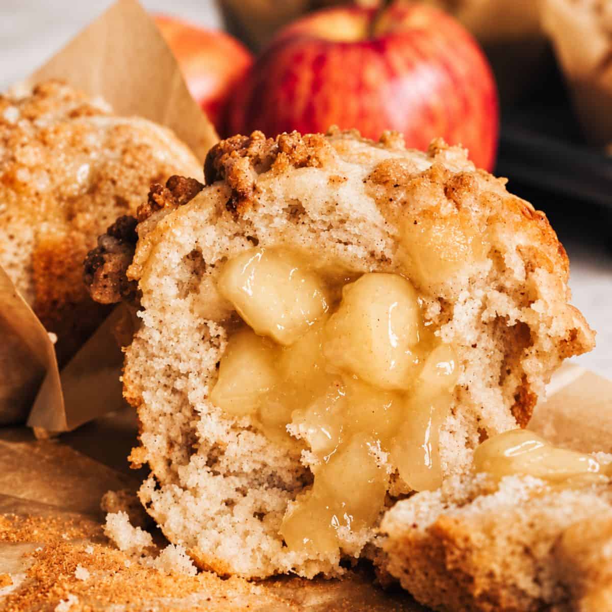Apple muffin cut open to show the soft apple pie filling in the center.