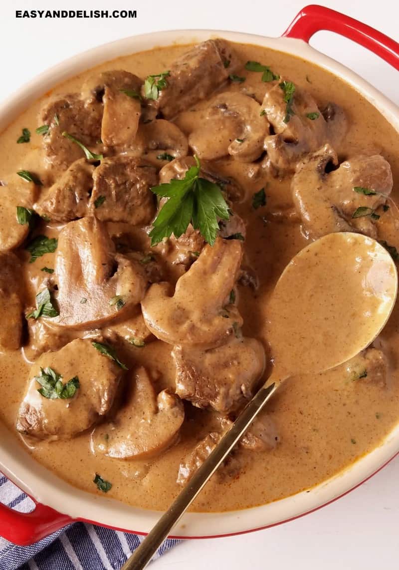 tigela com strogonoff de carne cremoso e uma colher ao lado