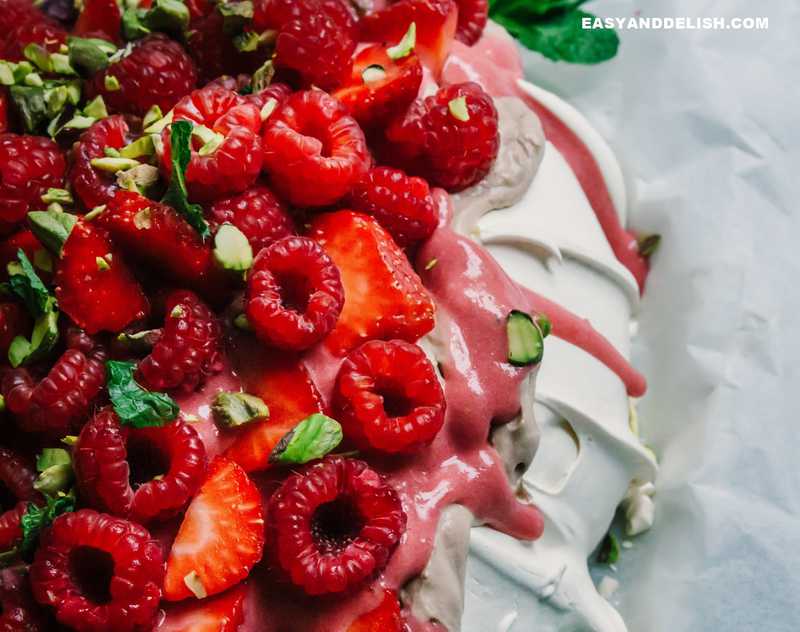 close up of pavlova with cream and berries