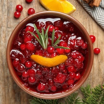 a bowl of keto cranberry sauce with orange peel adn rosemary