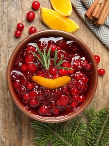a bowl of keto cranberry sauce with orange peel adn rosemary
