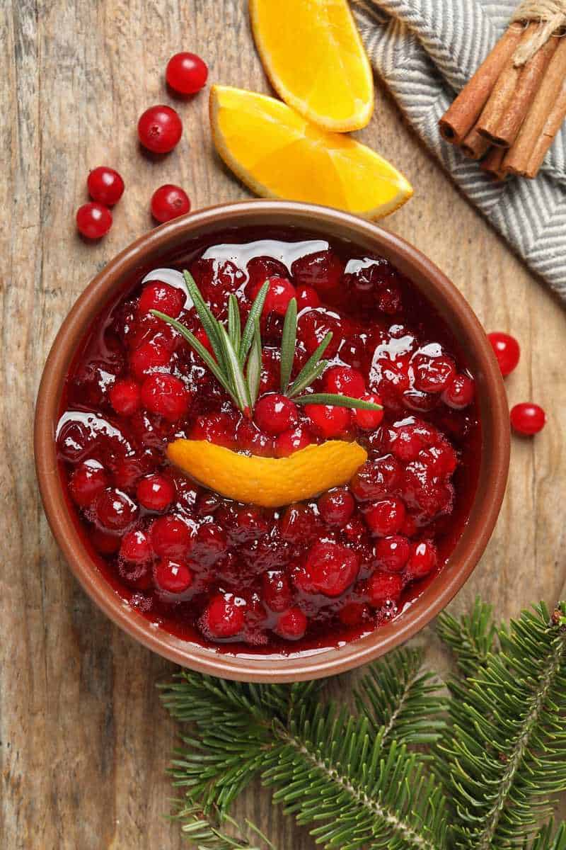 a bowl of keto cranberry sauce with orange peel adn rosemary