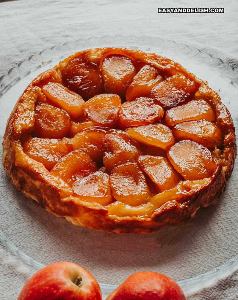 tarte tatin inteira com umas maçãs perto