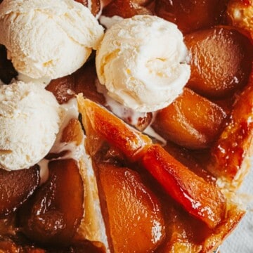 a slice of tarte tatin held up with the rest of the dessert under with ice cream