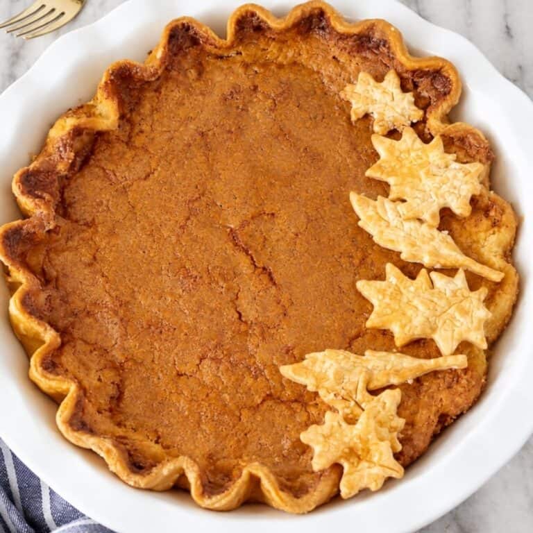 Overhead view of a golden brown buttermilk pie decorated with pastry leaves.