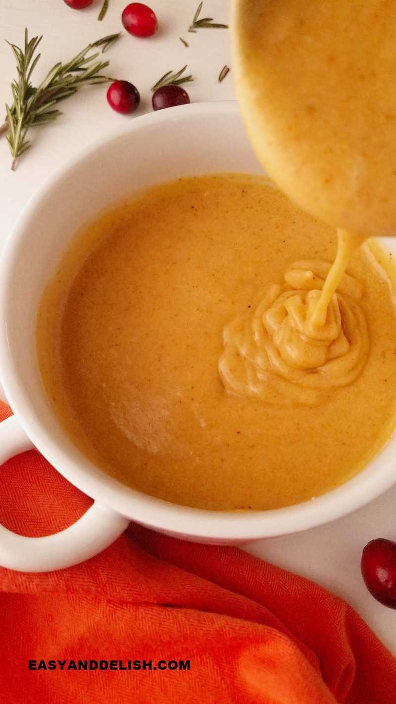 a laddle pouring gluten-free gravy inside of a bowl