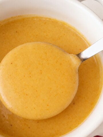 Gluten-Free Turkey Gravy in a white bowl with a spoonful lifted above it.
