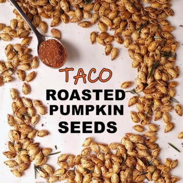 a bunch of roasted pumpkin seeds with a spoon of taco seasoning on the side