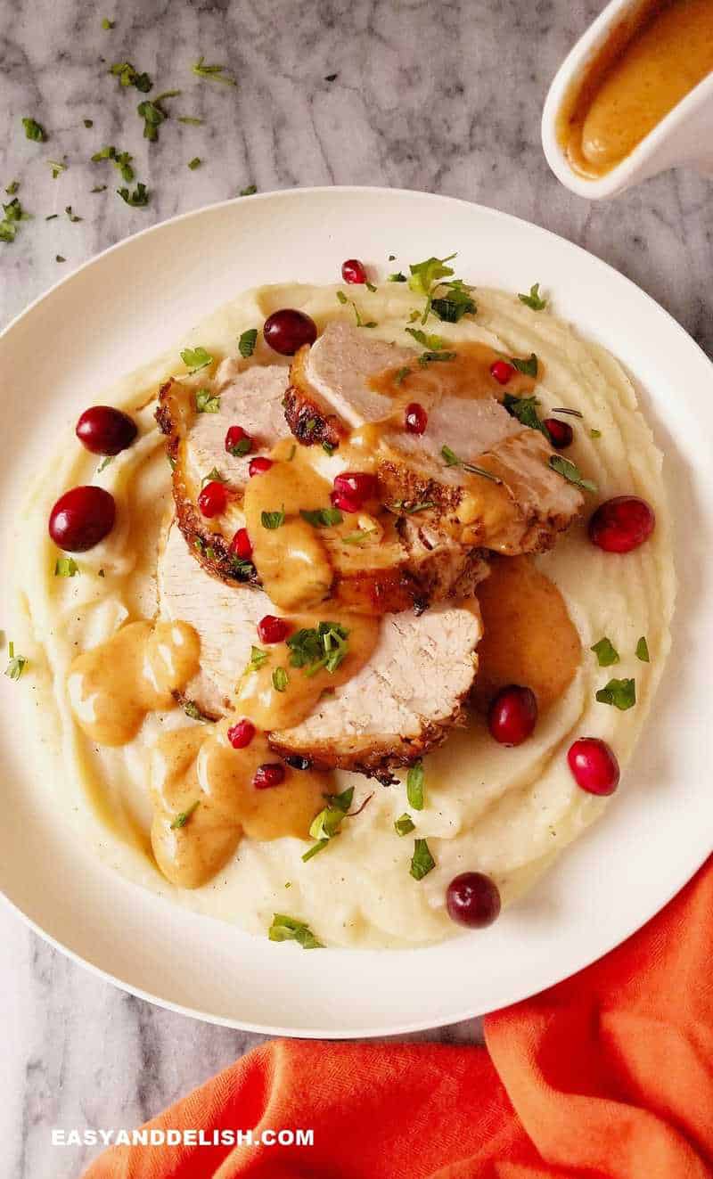 pressure cooker turkey breast in a plate about being topped with gravy