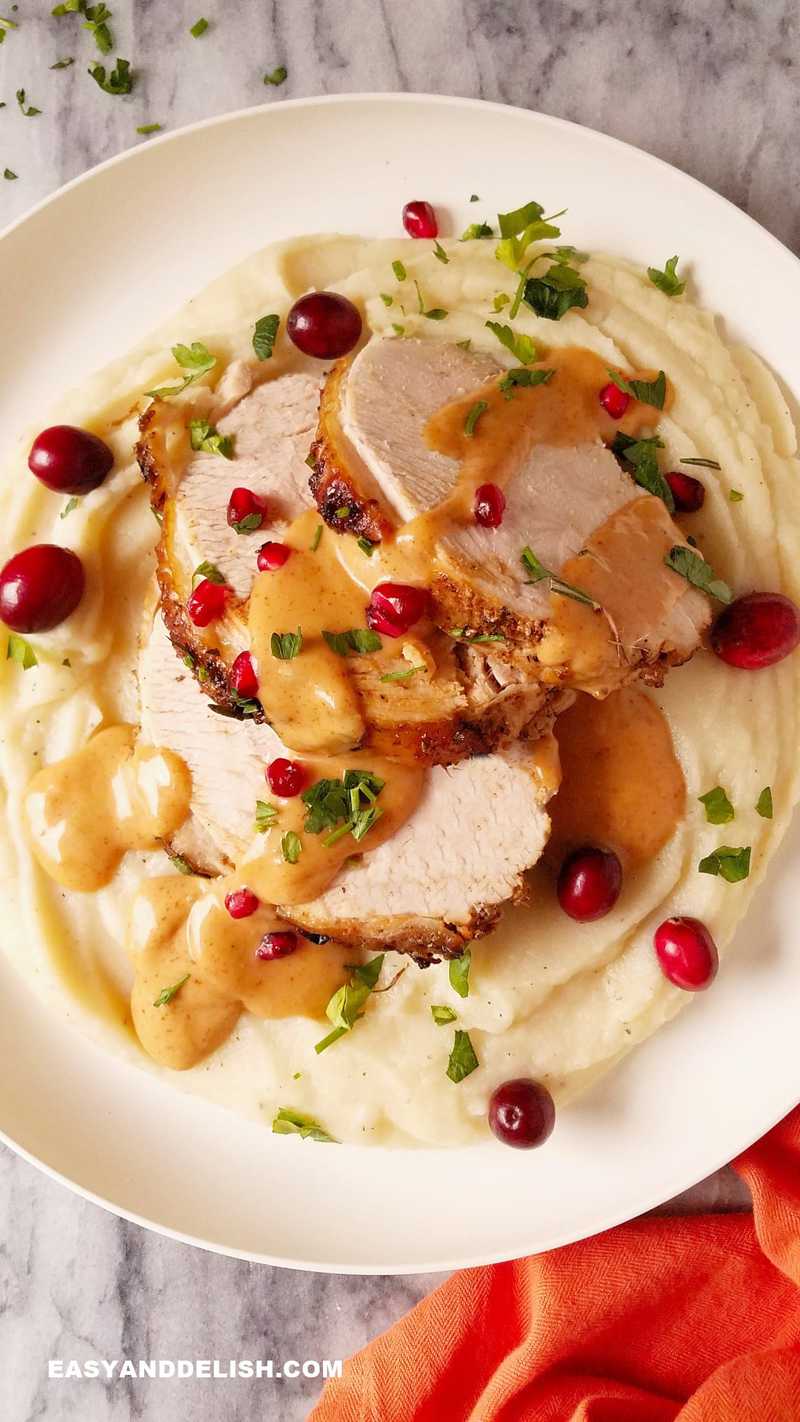 Instant Pot turkey breast sliced and served on top of mashed potatoes and drizzled with gravy