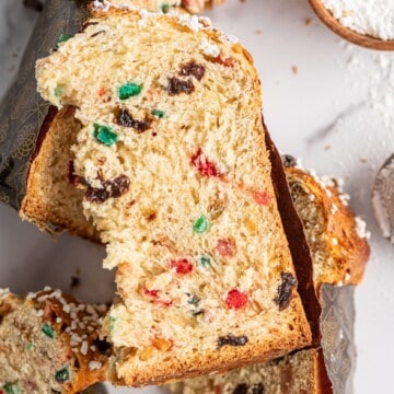 several slices of panettone with candied fruits over a table