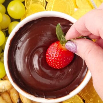 morango sendo mergulhado em fondue de chocolate