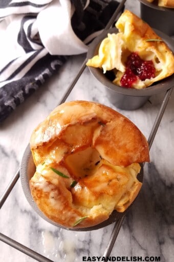 popovers in a popover pan, one whole and other open with jam