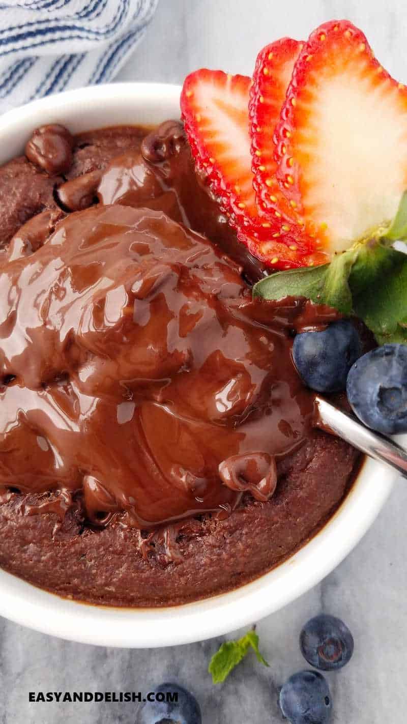 close up of baked oats with a molten chocolate center and berries