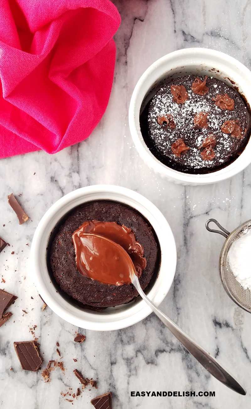 two ramekins with chocolate lava mug cake and pieces of chocolate on the side