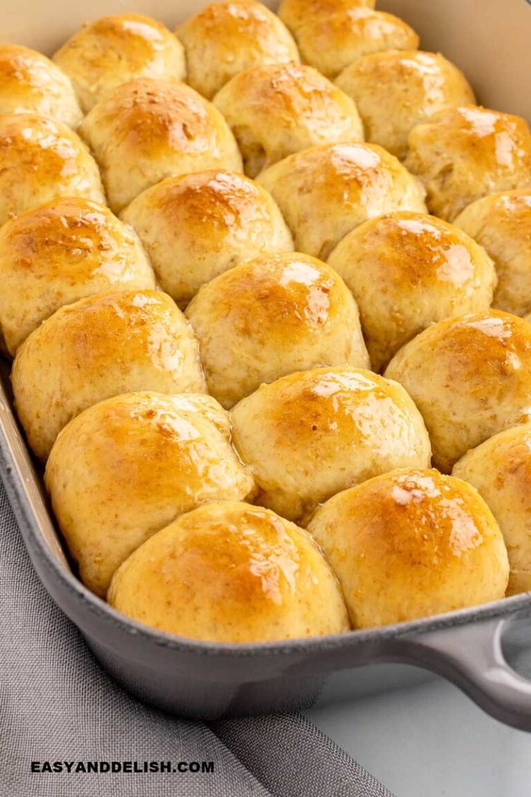 oat rolls brushed with honey butter in a baking dish