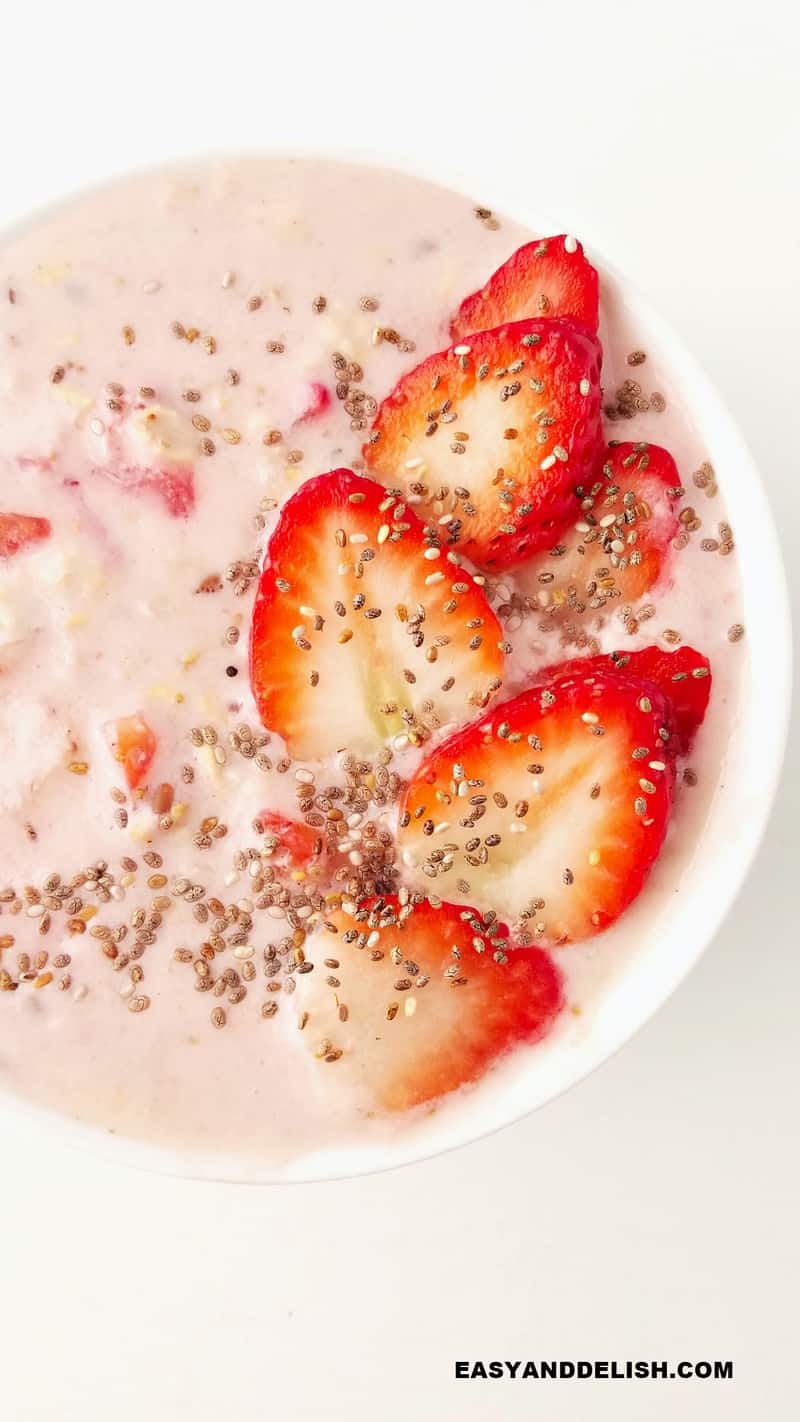 a bowl of strawberry and cream overnight oats with protein powder