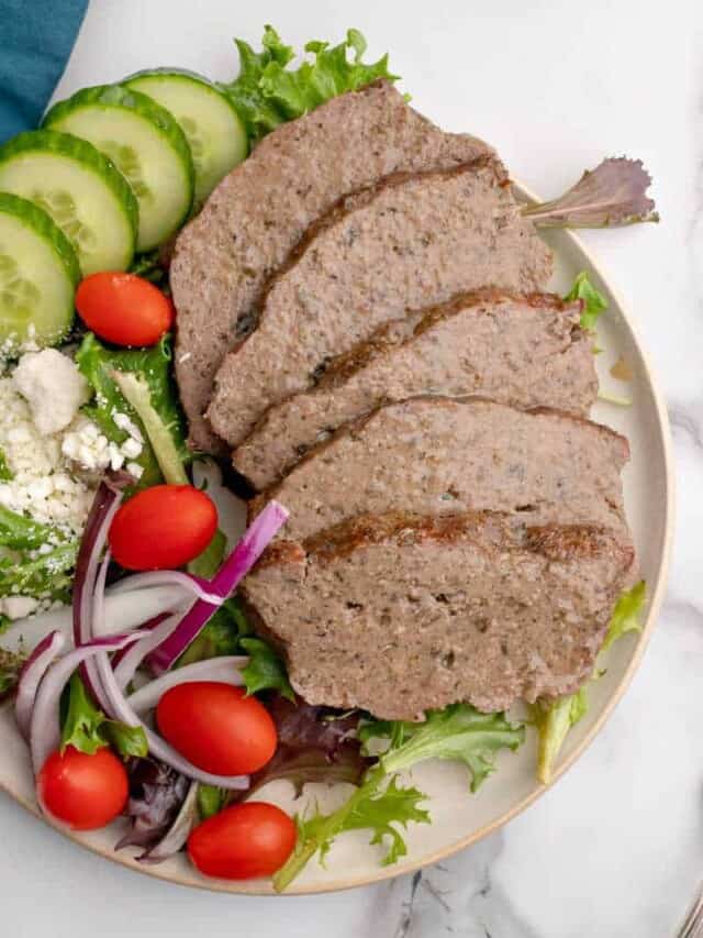 A plate of sliced gyro and veggies