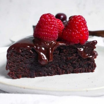 a slice of instant pot brownies with ganache and berries on top