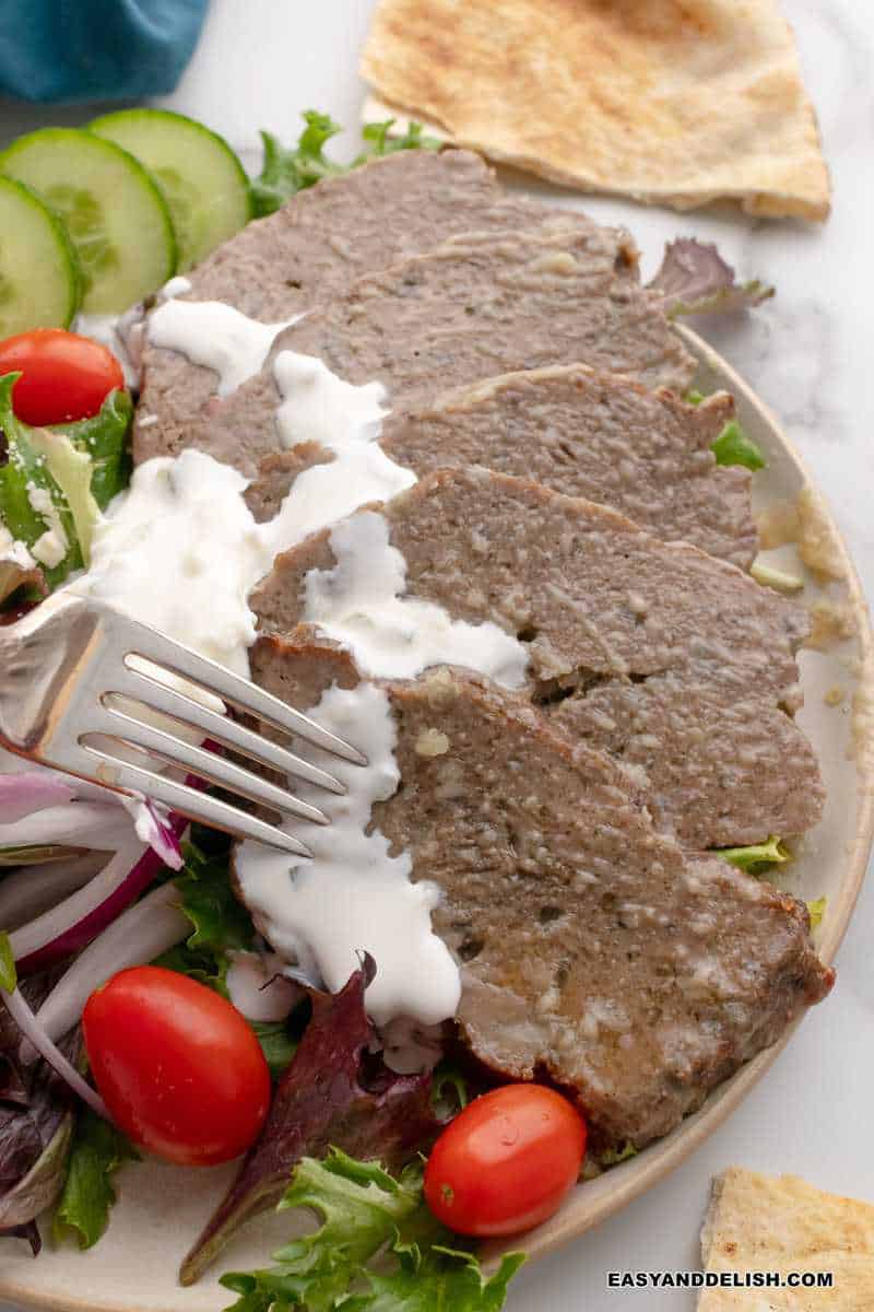 carne fatiada fina e servida com molho de iogurte e pepino (tzatziki)