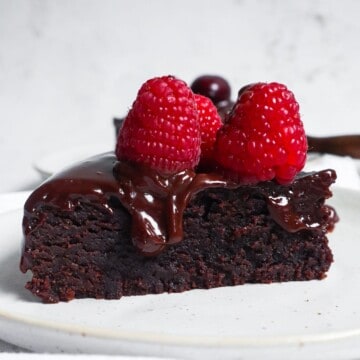 a slice of instant pot brownies with ganache and berries on top