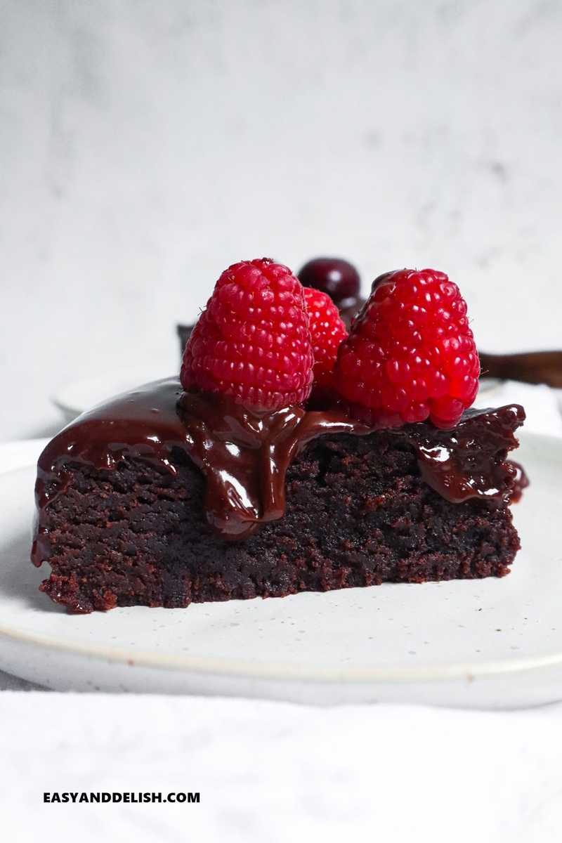 a slice of instant pot brownies with ganache and berries on top