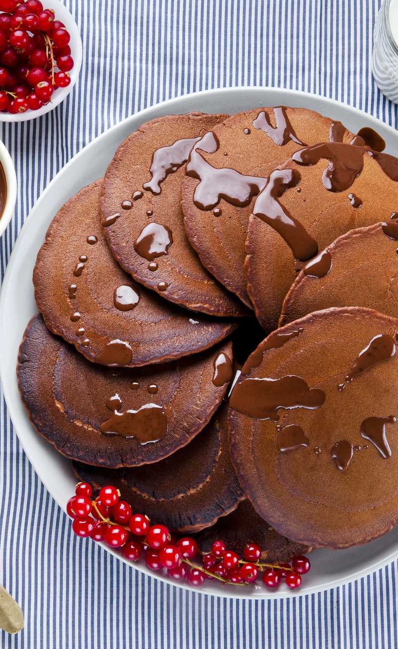 fanned oatmeal pancakes drizzled with melted chocolate in a plate