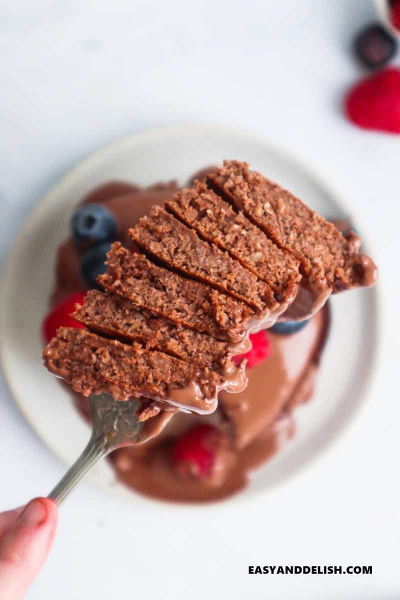 a fork raising a stack of sliced oat flour pancakes