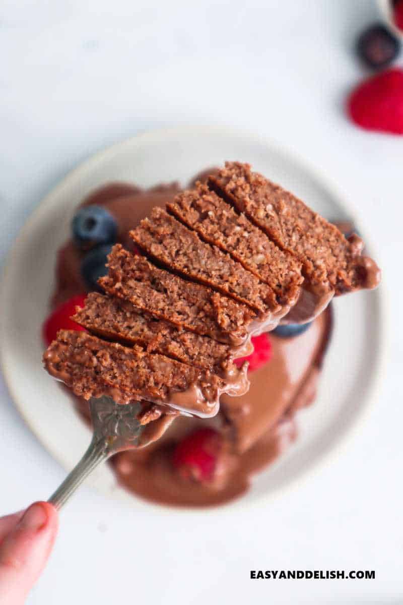 a fork raising a stack of sliced oat flour pancakes