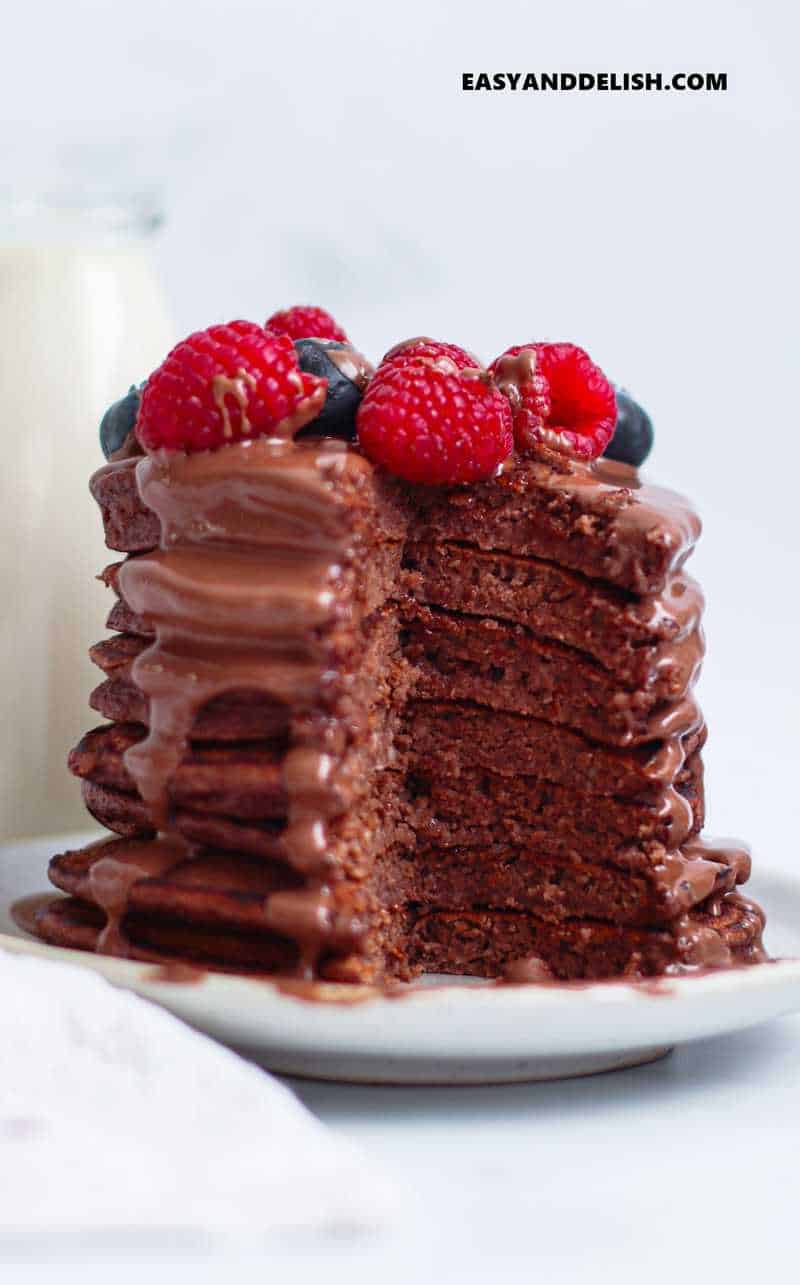 a stack of partially cut healthy breakfast with chocolate and berries