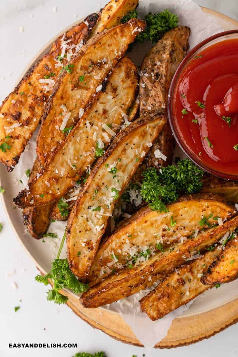 air fryer potato wedges with a side sauce and herbs