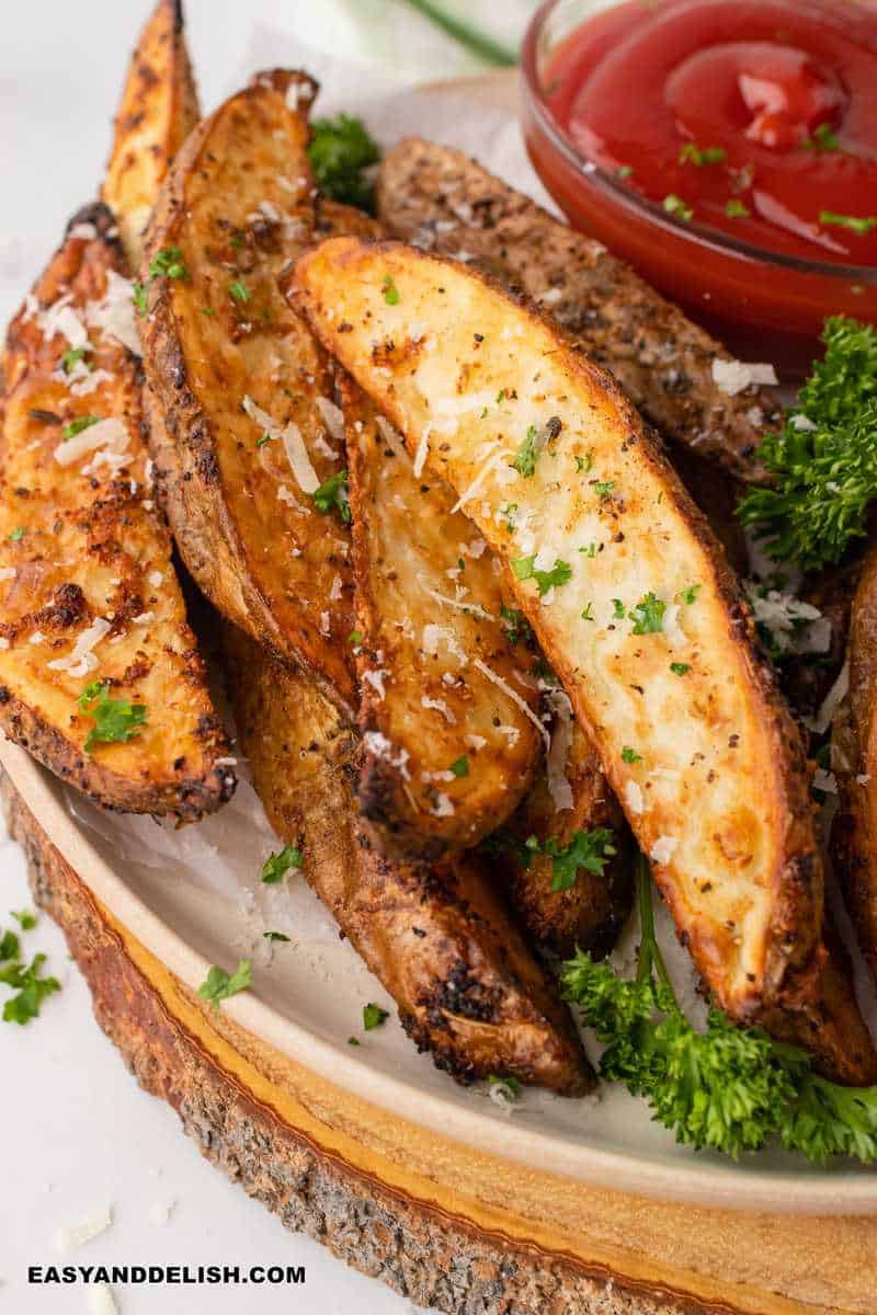close up of air fryer potato wedges with a sauce and parsley